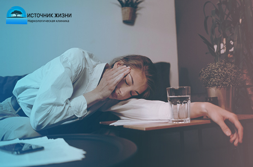 Женщина с больной головой лежит за столом