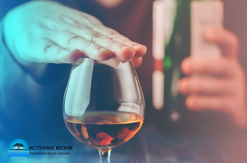 Женщина накрывает бокал рукой