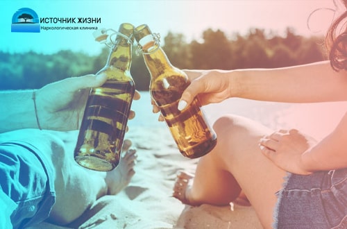 Парень и девушка пьют пиво в бутылках на пляже
