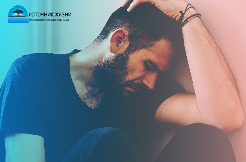 Мужчина в депрессии сидит, опустив голову
